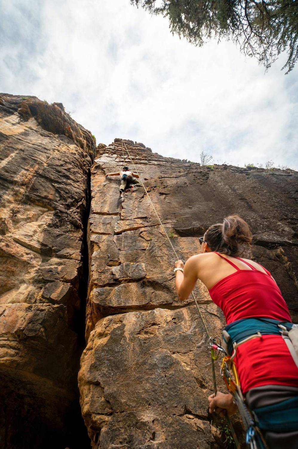 Rock climber rappelling down a sunlit cliff face