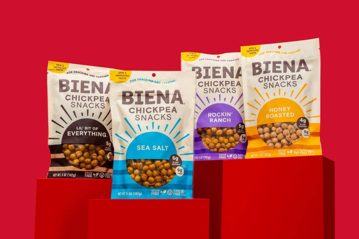 Chickpea snack bags on red pedestals against a red background