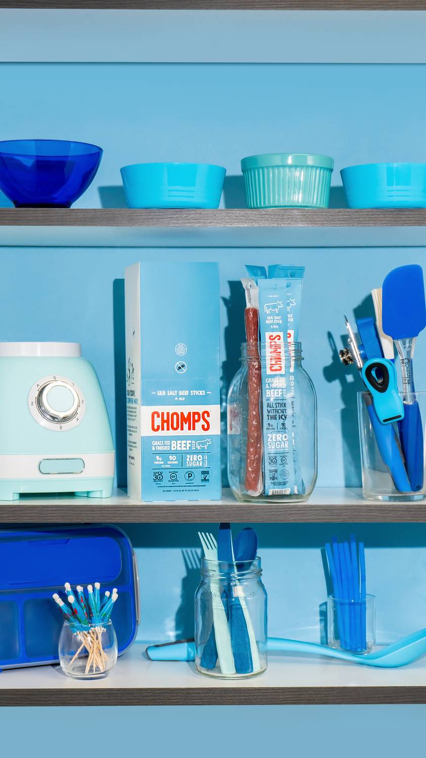 Beef stick snacks styled on a blue kitchen shelf