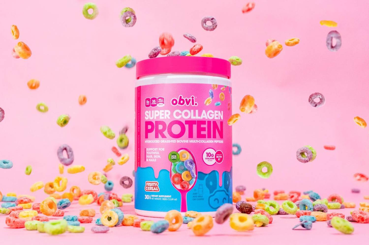 Collagen protein tub with cereal flying around it on a pink background