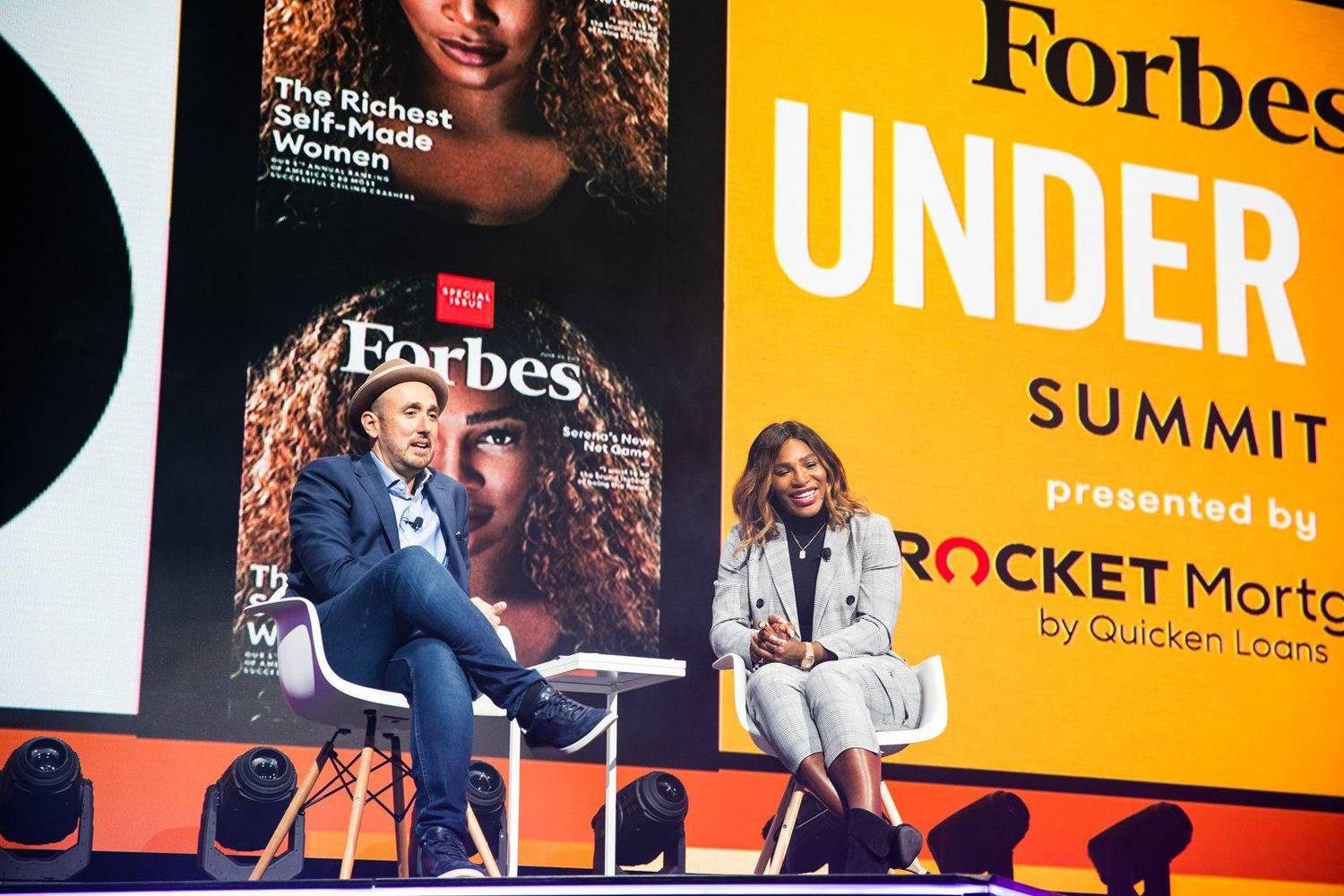 Fireside chat panel discussion on stage in front of a Forbes Under 30 Summit backdrop