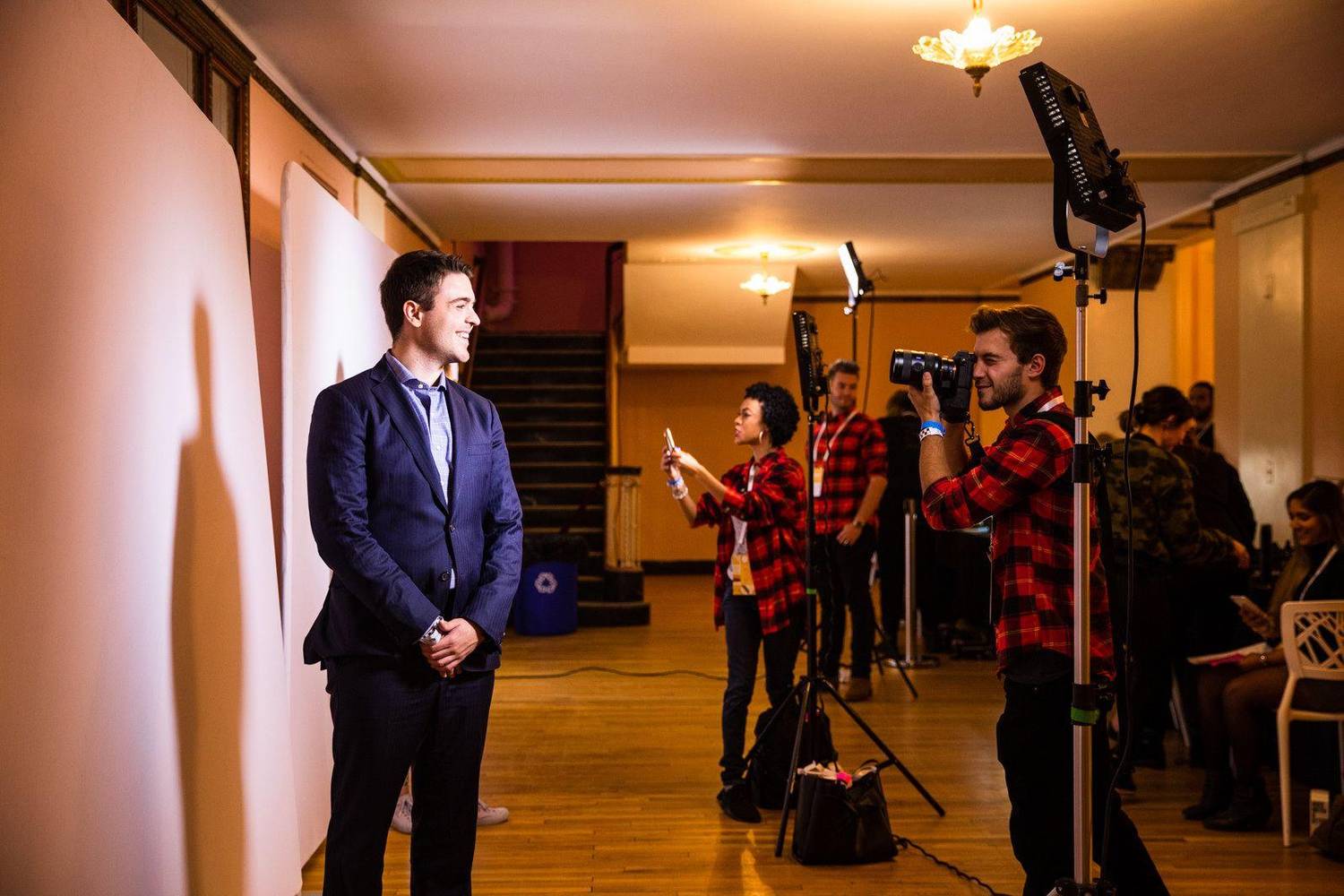 Photographer taking a portrait of an attendee at an event photo booth