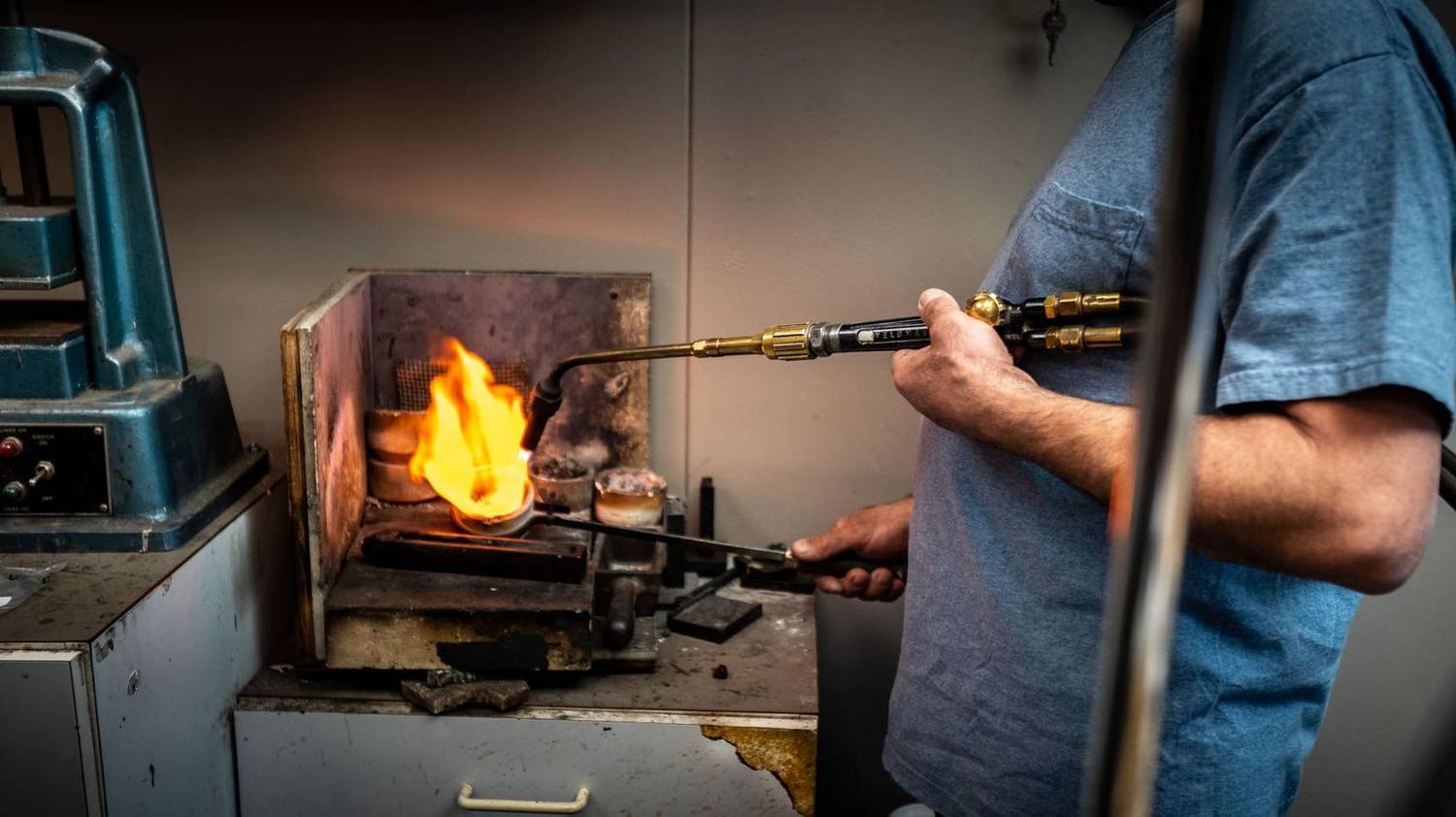 Close-up of a torch soldering metal at a jewelry workbench