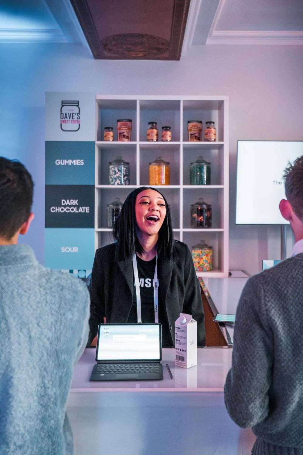 Brand representative greeting attendees at a trade show booth