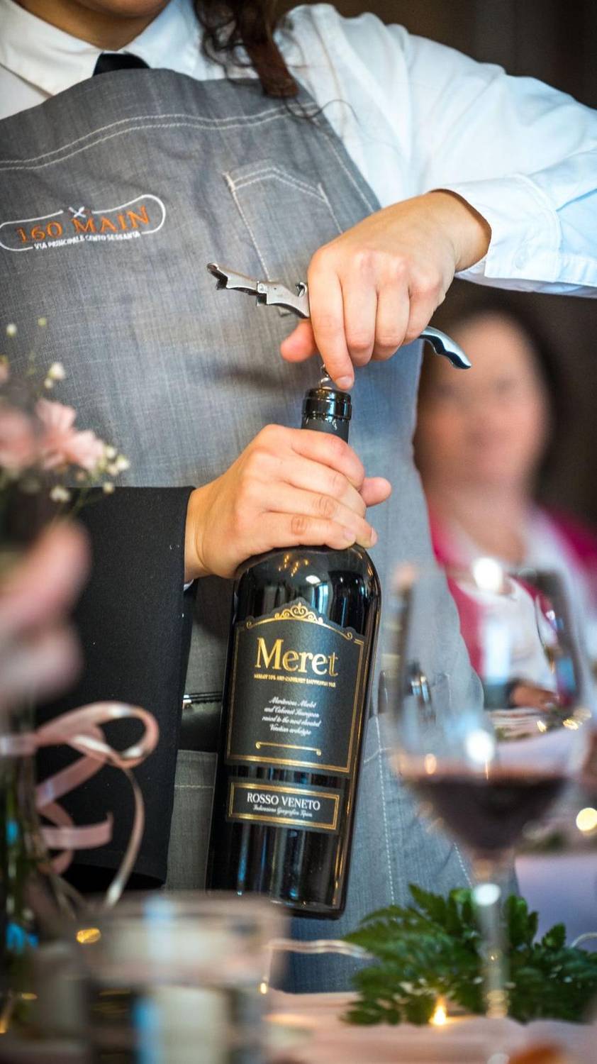 Server pouring wine at a private dining event
