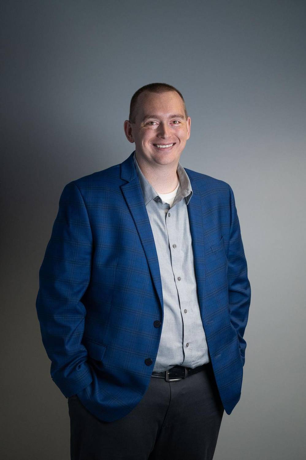 Corporate headshot of a man in a blue blazer