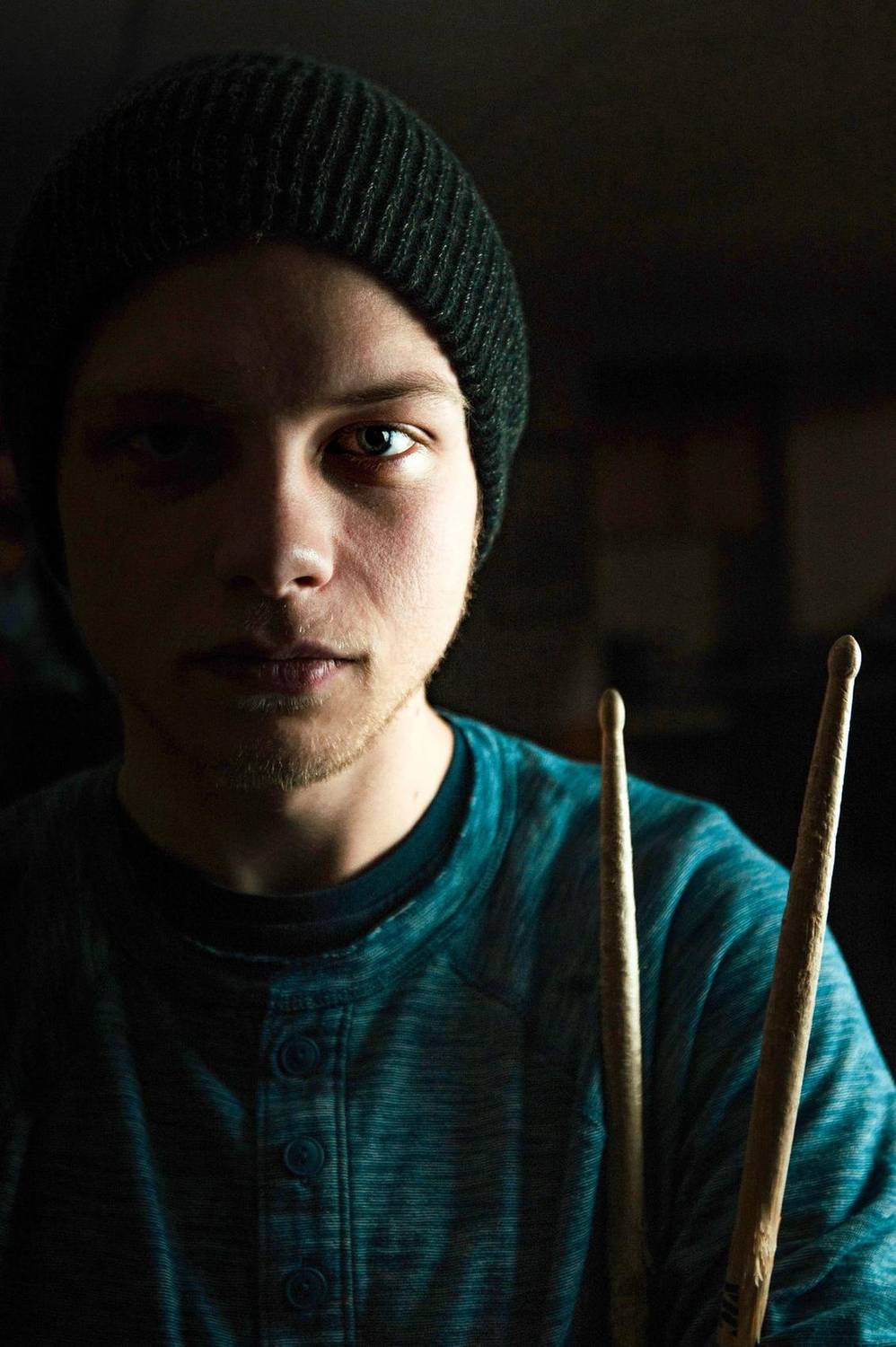 Dramatic portrait of a man holding drumsticks