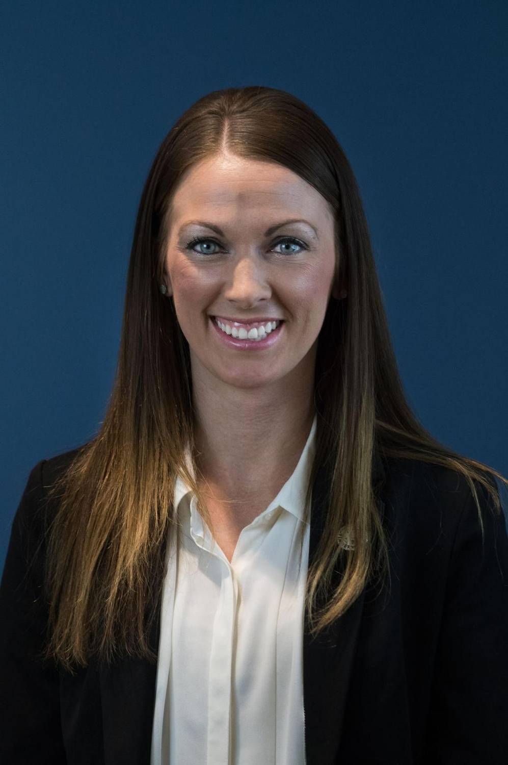 Corporate headshot of a woman against a blue background