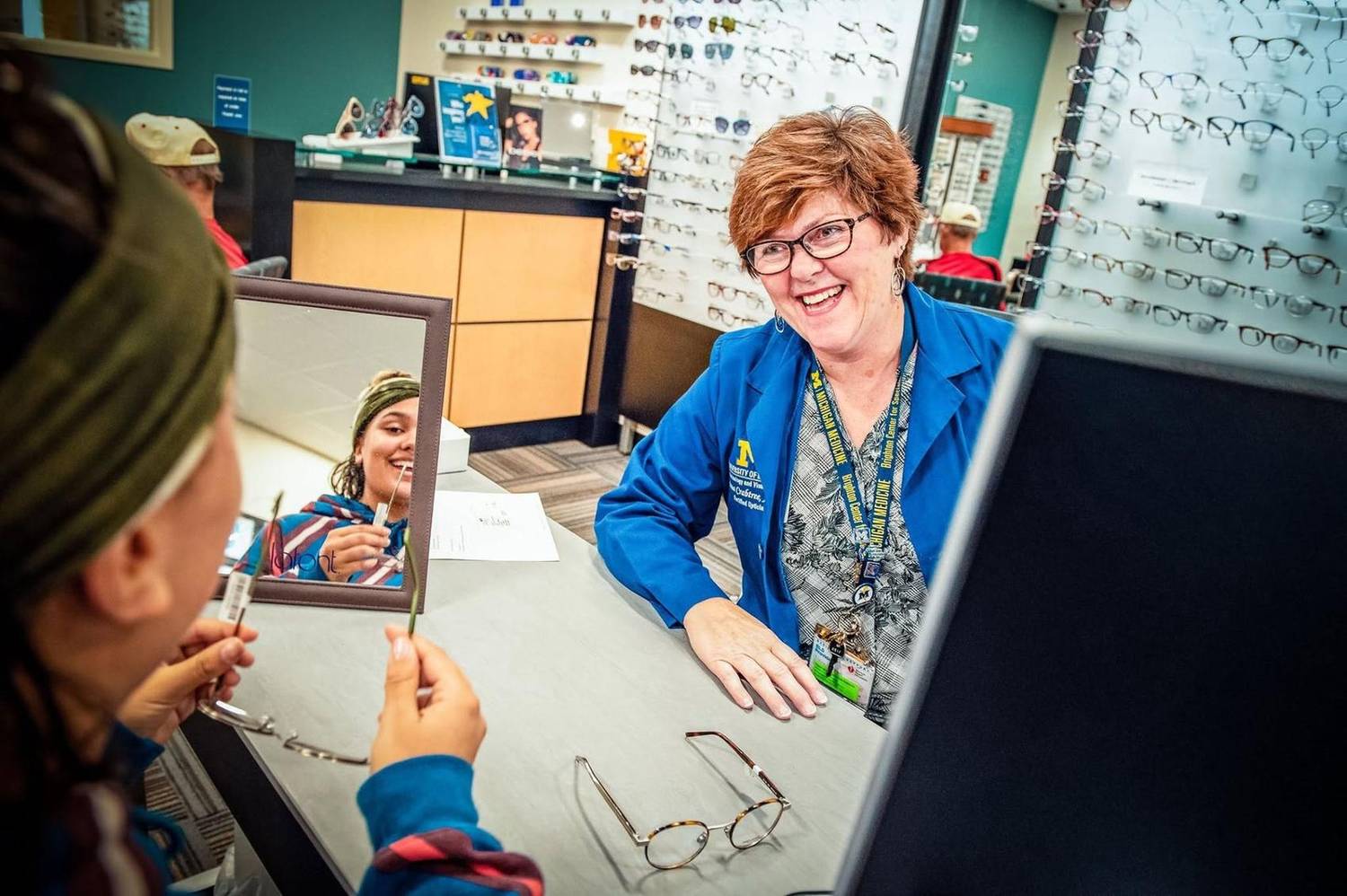 Optician helping a customer choose glasses in an eyewear shop