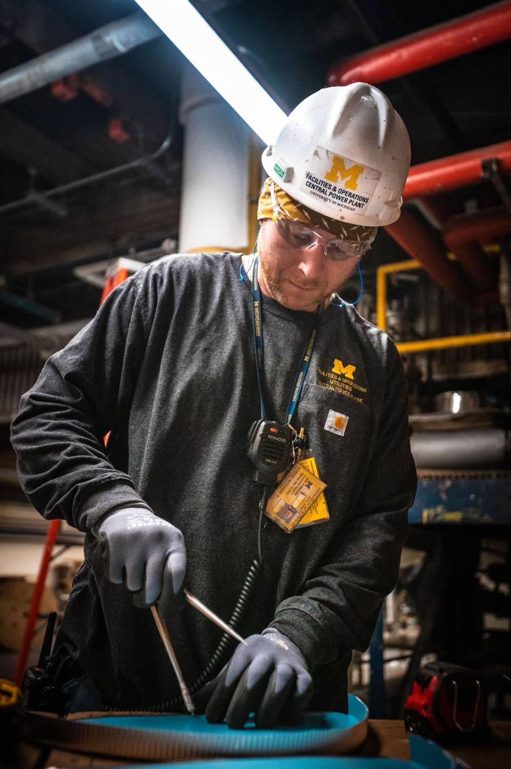 Facilities worker soldering pipework inside a power plant