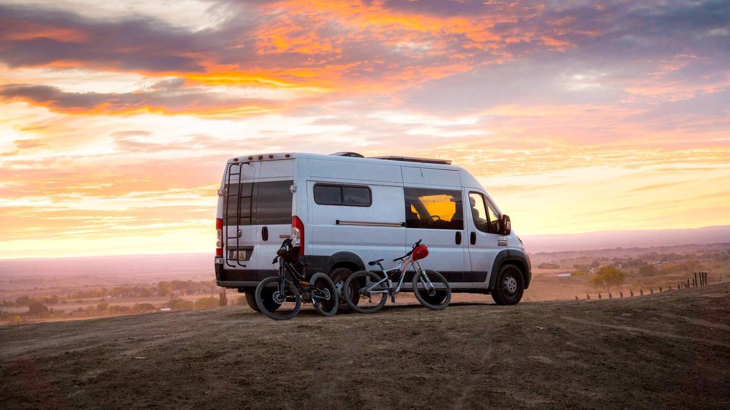 Camper van with mountain bikes parked at sunset