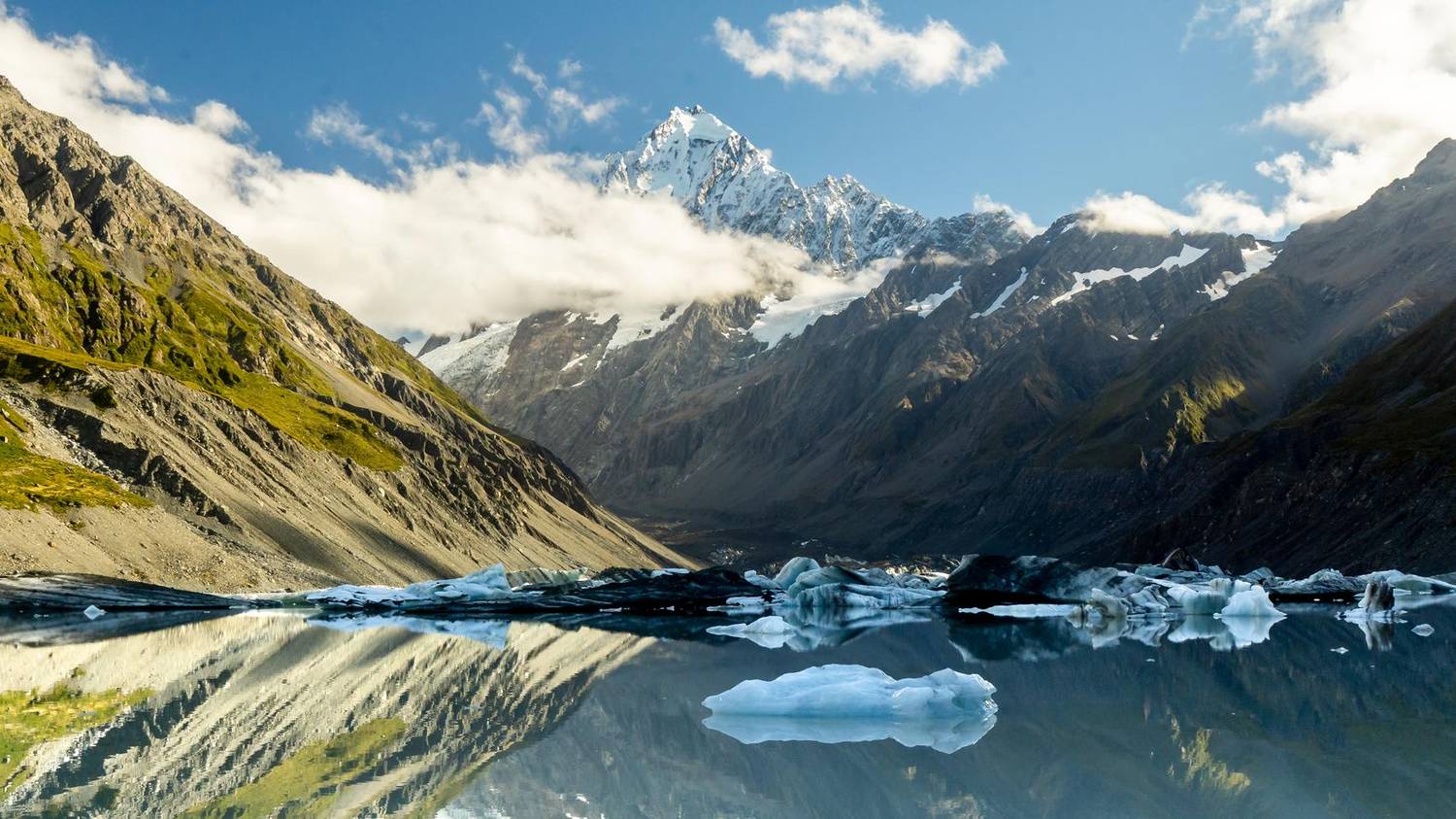 Glacial lake with icebergs beneath a snow-capped peak