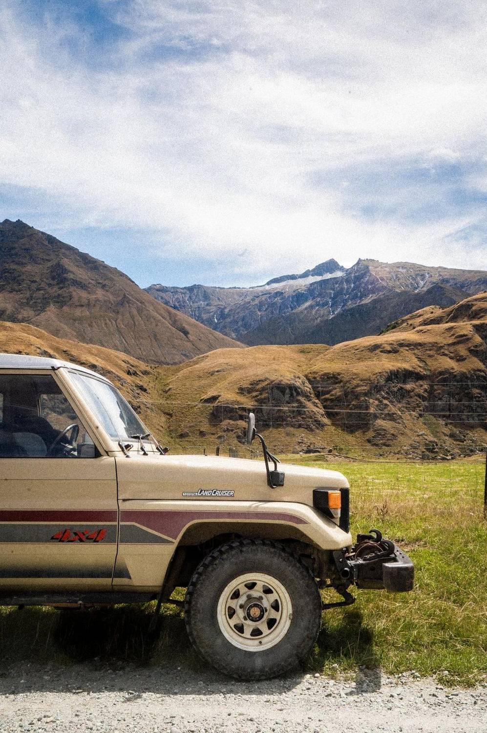 Vintage Toyota Land Cruiser parked in front of mountain scenery