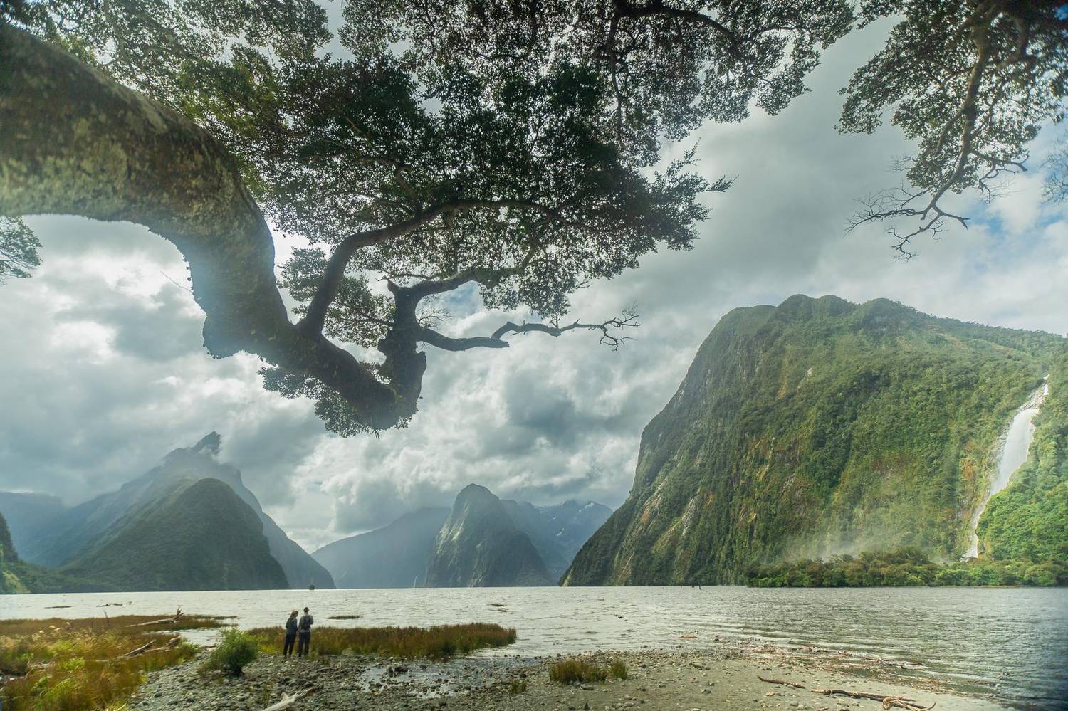 Fjord framed by a mountain ridge and low clouds