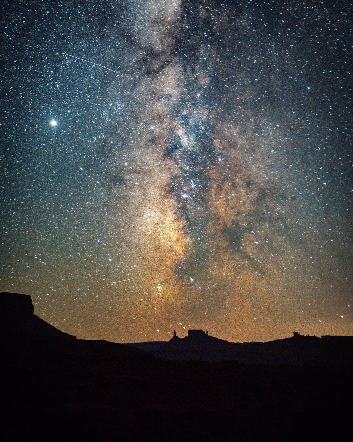 Milky Way arcing over silhouetted desert rock formations