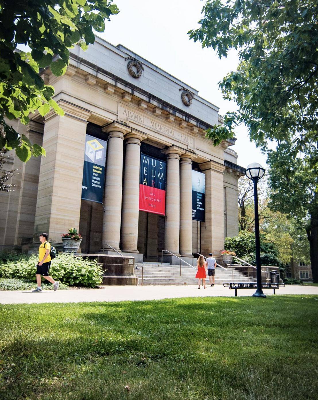 Classical museum building entrance with visitors on the lawn