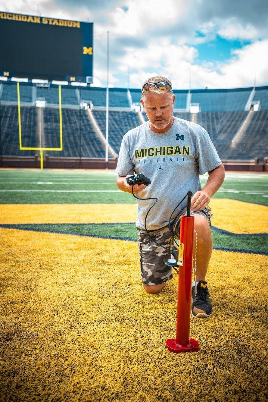 Groundskeeper setting up a down marker on the field at Michigan Stadium